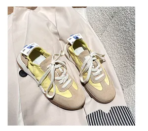 Close-up of beige suede leather and yellow fabric texture on retro trainer shoes