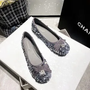 Sparkly silver sequin ballet flats with bow and rhinestone buckle on white box