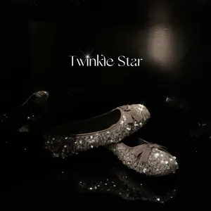 Ballerine glitterate argento con fiocco e suola spessa su sfondo nero lucido