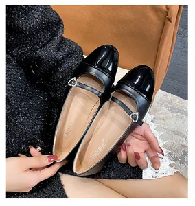 Detalle de los zapatos Mary Jane negros con punta de charol y hebilla de cristal de corazón