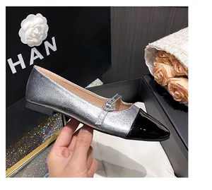 Detalle de zapato Mary Jane plateado con puntera negra y hebilla de corazón con brillantes