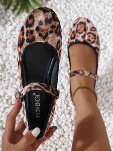 Detailed view of leopard print Mary Jane flat shoes with adjustable buckle on pebble ground