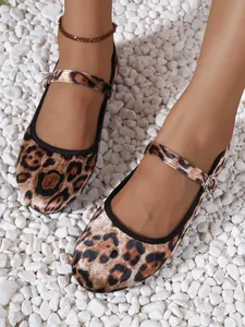 Detail of leopard print Mary Jane flat shoe with adjustable buckle strap on white pebbles