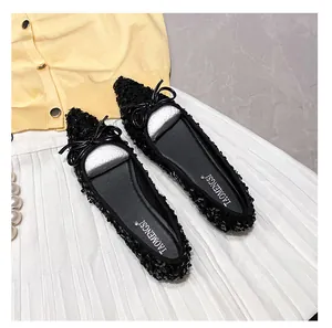 Close-up of black sequined pointed toe flats with a bow detail on an elegant backdrop