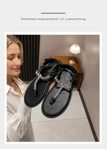 Close-up of black thong sandals featuring sparkling crystal knots on a soft indoor background