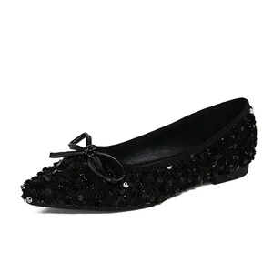 Elegant black sequin pointed toe ballet flats with delicate bow accent on white background