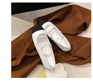 Détail de ballerines Mary Jane bicolores avec bout rond noir et bride élastique blanche