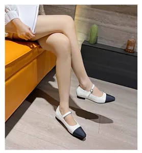 Elegant two-tone Mary Jane shoes with black cap toe and white leather finish on feet