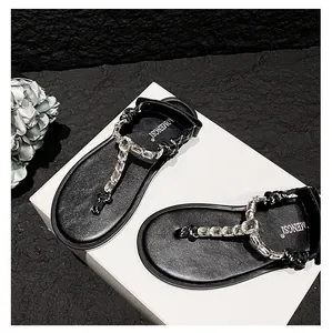 Detailed top view of black T-strap flip flops with sparkling rhinestones on leather sole