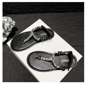 Detail of black thong sandals featuring sparkling rhinestone chains and braided rope design