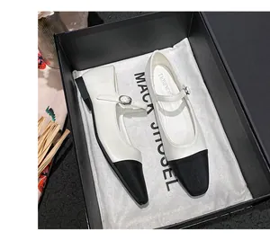 Detail shot of two-tone Mary Jane shoes in a gift box with branded dust cloth