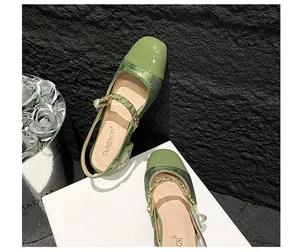Nahaufnahme grüner Mary Jane Pantoletten mit goldener Kette, Perle und Webstoff