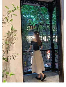 Haut noir épaules nues élégant avec jupe midi beige taille haute en scène de nuit