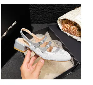 Detailopname van zilvergrijze jacquard Mary Jane schoenen met dubbele gesp en blokhak
