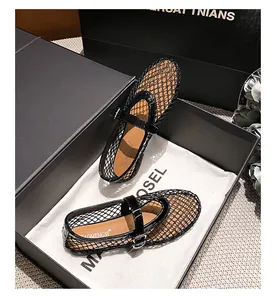 Detailed close-up of black mesh Mary Jane flats with glossy leather trim in a gift box