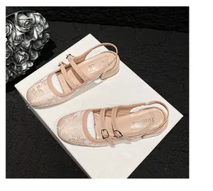 Detailweergave van beige Mary Jane schoenen met bloemen jacquardpatroon en dubbele gespen