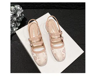 Detailopname van beige Mary Jane-schoenen met gebloemde jacquardtextuur en dubbele gespen