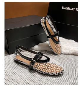 Detailed macro view of white mesh Mary Jane flats with black patent leather straps