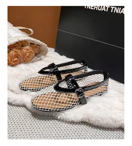 Close-up of white mesh Mary Jane flats with black patent trim on soft plush rug