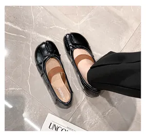 Close-up of black Tabi ballet flats featuring soft sheepskin and elastic crossover straps