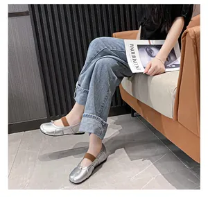 Detail of silver metallic Tabi flats with brown elastic strap in a lifestyle setting
