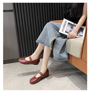 Detailed close-up of dark red soft leather flat shoes with round toe and pleated design