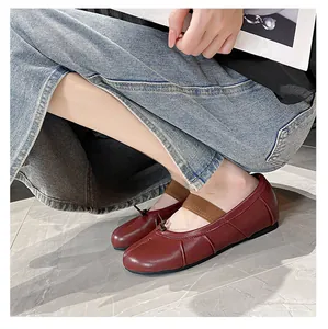 Macro detail of burgundy sheepskin flat shoe featuring pleated leather and elastic strap