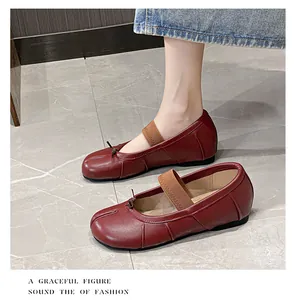 Close-up of deep red sheepskin Tabi ballet flats with elastic strap and bow detail