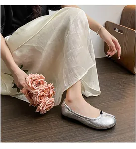 Detail of silver Tabi ballet flats with black bow and metallic texture on a model