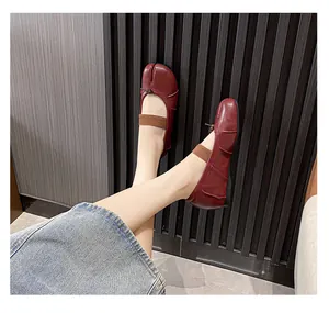 Detail of burgundy Tabi split-toe leather flats with elastic strap and bow tie