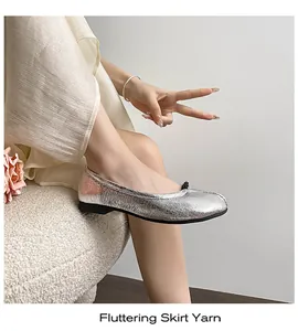 Close-up of silver ballet flats featuring metallic crinkle texture and delicate bow