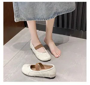 Detail shot of cream white soft leather Tabi flats with contrasting dark brown elastic strap
