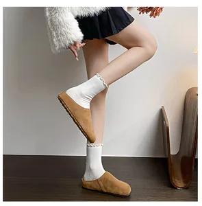 Brown suede platform mule shoes with round toe style paired with white lace socks