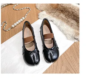 Close-up of black Tabi flats with leather texture and elegant bow details for women