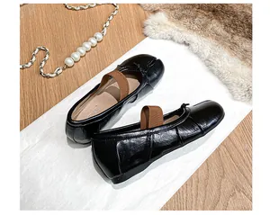 Top view of black Tabi split-toe ballet flats with elastic strap and bow detail