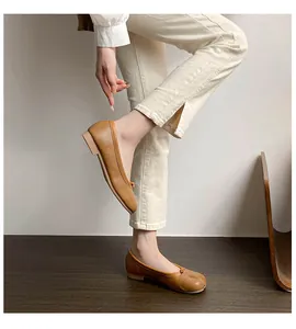 Detailed view of brown leather tabi flat shoes with split-toe design for women on feet