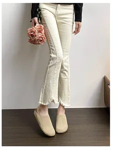 Detail of cream flare pants with fringed hem and central decorative seam detail