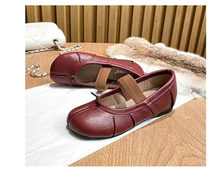 Detailed close-up of dark red leather Tabi ballet flats featuring a bow and elastic strap