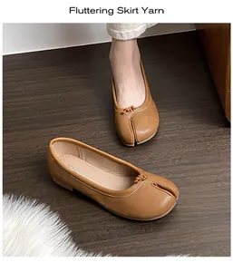 Detail of brown leather Tabi flat shoes with split-toe design and decorative knot detail