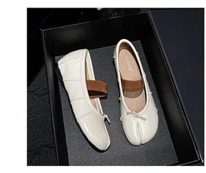 Detailed top view of cream Tabi ballet flats with ribbon bow and elastic strap