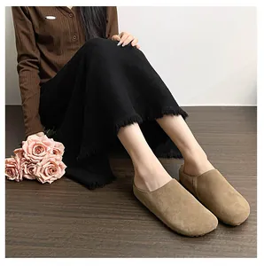 Detail view of light brown suede leather mule shoes with round toe and premium stitching