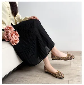 Detail of leopard print ballet flats featuring a brown bow and elegant suede texture