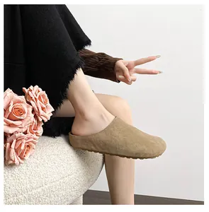 Close-up of khaki suede mule slipper on feet with platform sole and round toe design