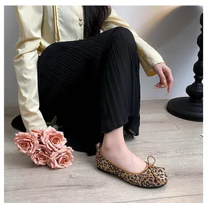 Detail shot of leopard print ballet flats featuring a delicate bow on the square toe