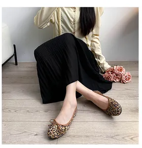 Chic leopard print square toe ballet flats with bow detail worn with a pleated skirt