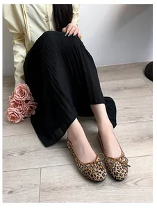 Close-up of leopard print ballet flats with delicate bow and brown edge piping