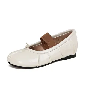 Minimalist beige sheepskin Mary Jane flats with split-toe design and brown elastic strap