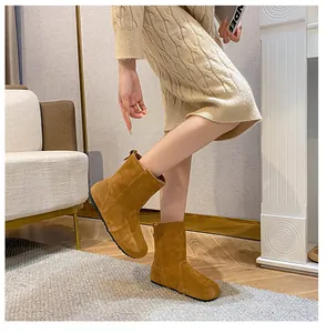 Detail von gelben Wildleder-Stiefeletten mit matter Textur und flachen schwarzen Sohlen