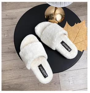 Top view of white faux fur cross strap slippers with soft plush texture and woven logo