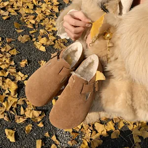 Women's warm suede camel clogs with thick faux fur lining on autumn ginkgo leaves